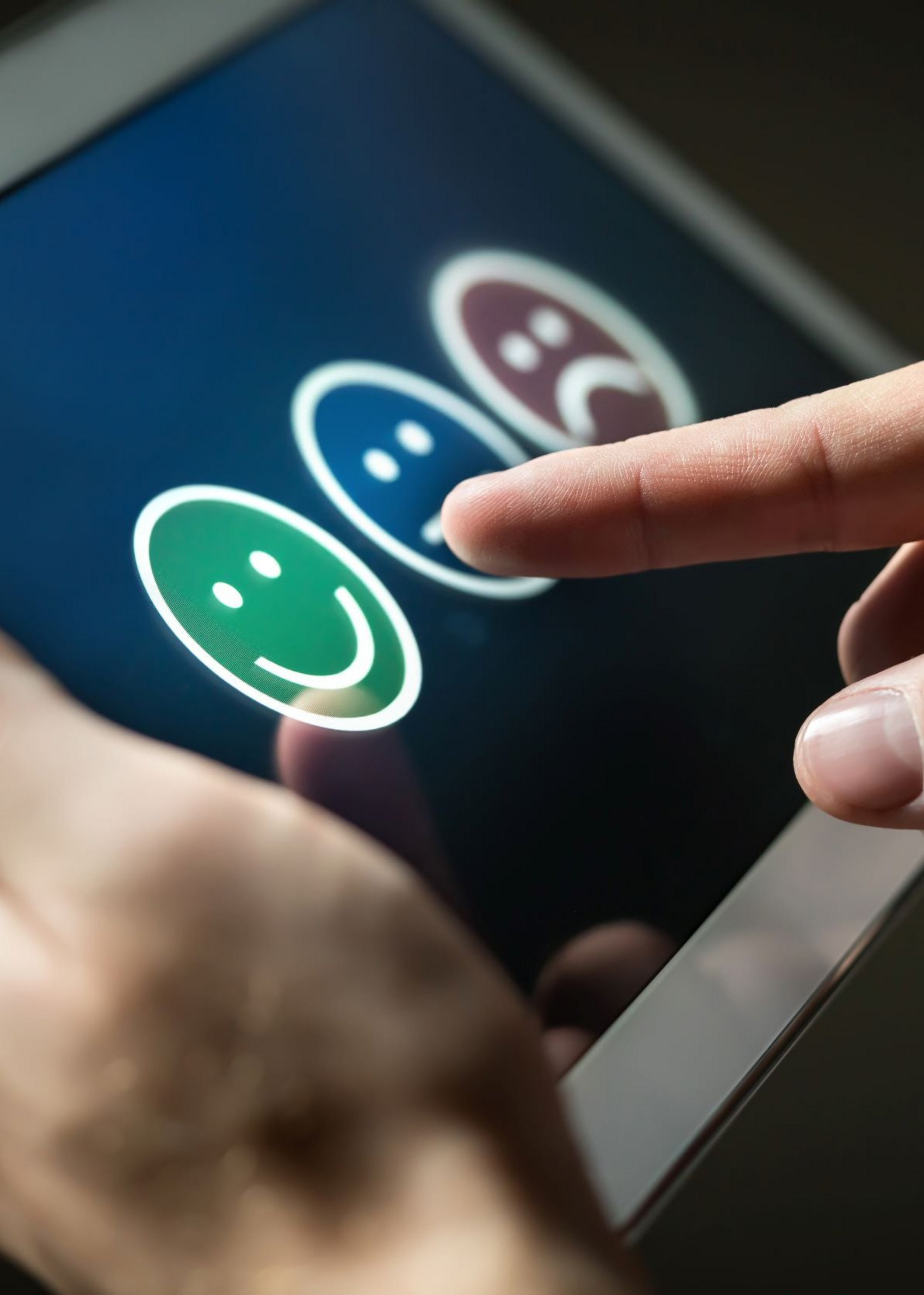 Person holder tablet med glad, neutral og sur smiley. Colourbox, #185712.