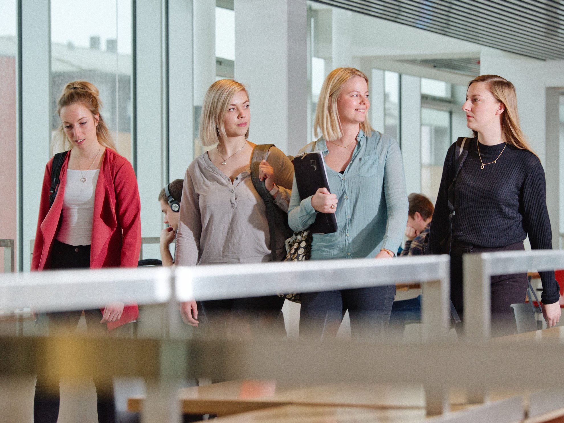 4 kvindelige studerende går på gang.